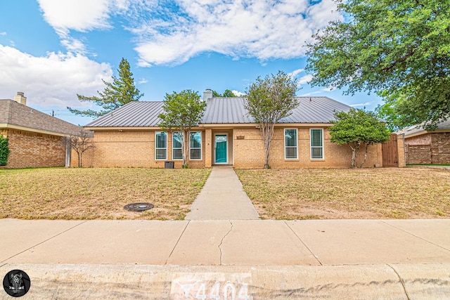 4404 Westminister Dr, Midland, TX 79707 - view of front of property with brick siding, metal roof, and a chimney