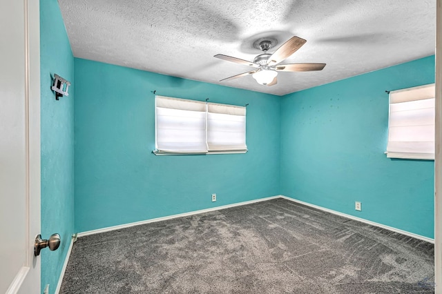 carpeted spare room featuring a textured ceiling, baseboards, and ceiling fan