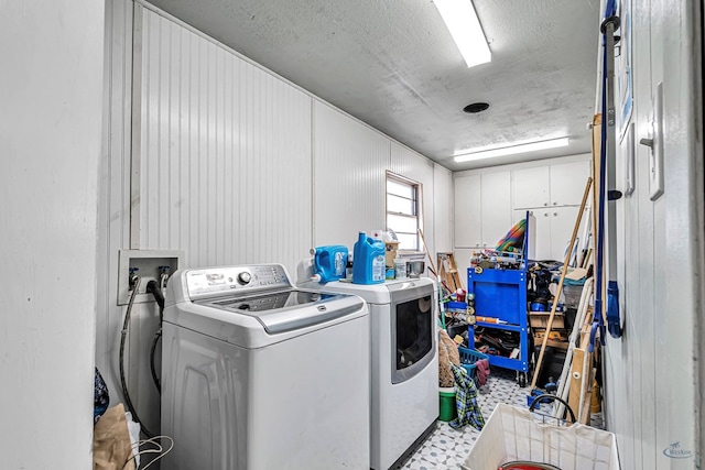 washroom featuring washer and dryer, light floors, and a textured ceiling