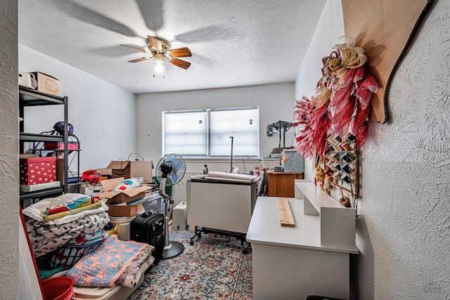 home office featuring a textured ceiling, ceiling fan, and a textured wall