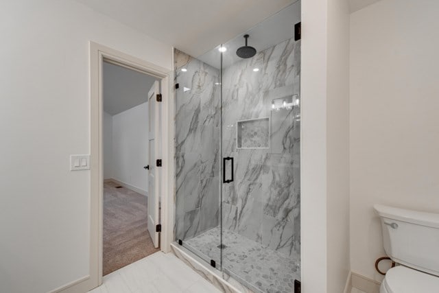 bathroom with an enclosed shower and toilet