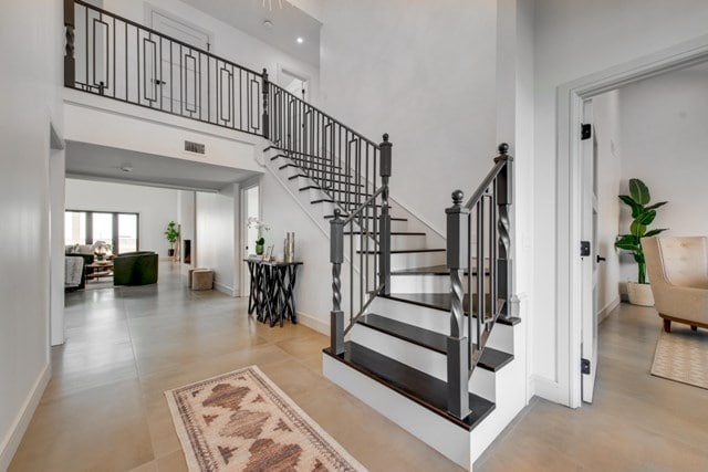 stairs featuring a towering ceiling