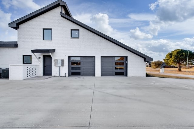 view of side of property with cooling unit and a garage