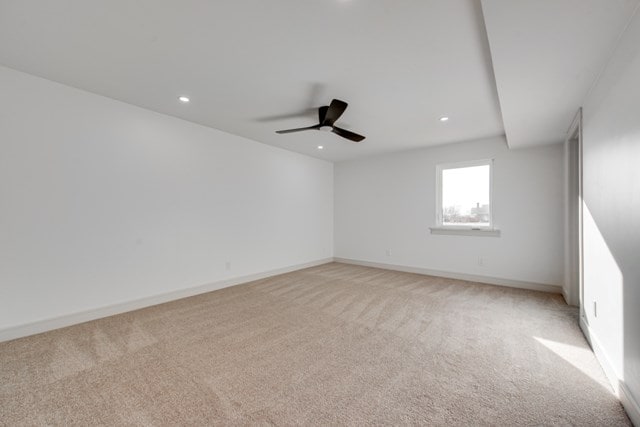 unfurnished room with ceiling fan and light carpet