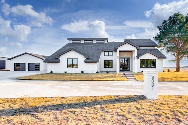 modern farmhouse featuring a front yard and a garage