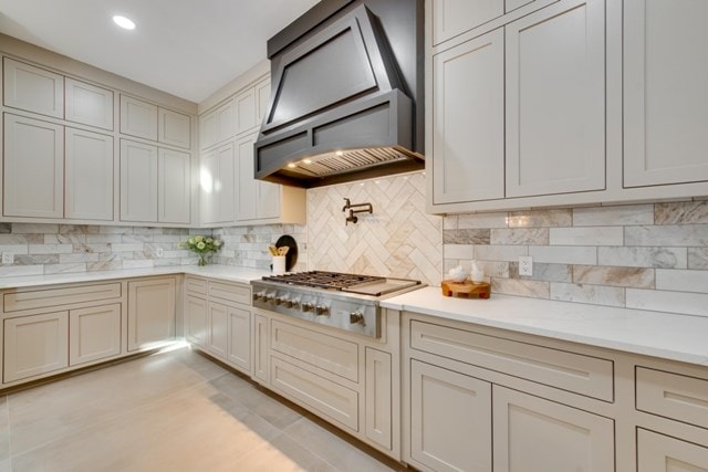 kitchen featuring tasteful backsplash, stainless steel gas stovetop, and custom range hood