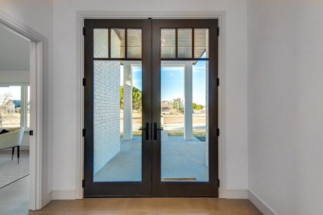 doorway with french doors and light tile patterned floors