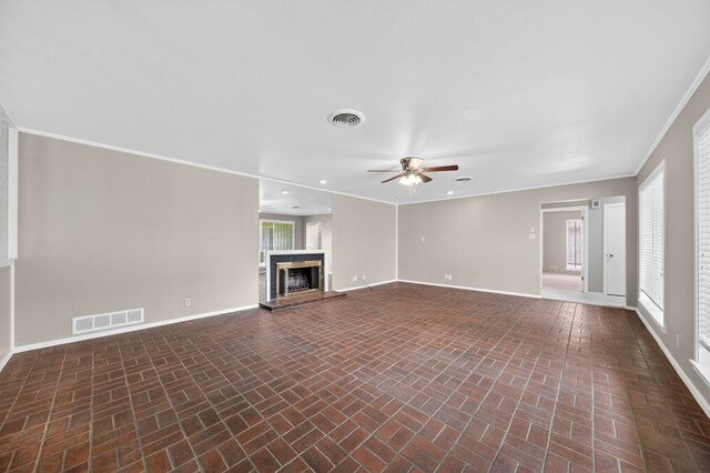 1406 W Pecan, Midland, TX 79705 - unfurnished living room with brick patterned floors, a ceiling fan, a fireplace with raised hearth, ornamental molding, and recessed lighting