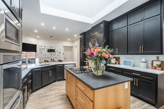 5807 Sterling Pl, Midland, TX 79707 - kitchen featuring appliances with stainless steel finishes, a sink, light wood-style floors, recessed lighting, and a center island