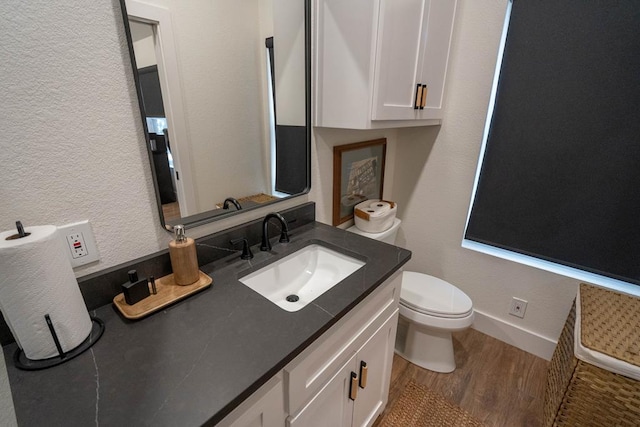 5807 Sterling Pl, Midland, TX 79707 - half bathroom featuring wood finished floors, toilet, vanity, baseboards, and a textured wall