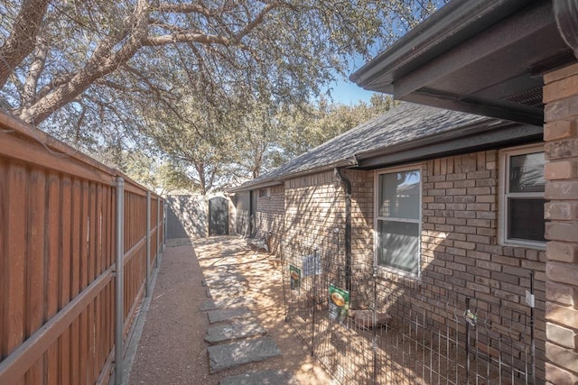 5807 Sterling Pl, Midland, TX 79707 - view of side of property featuring a fenced backyard, roof with shingles, a patio area, and brick siding