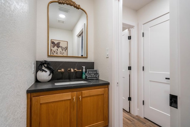 5807 Sterling Pl, Midland, TX 79707 - bathroom with vanity, wood finished floors, and a textured wall