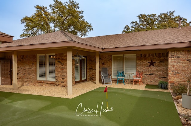 back of property with a patio, brick siding, and roof with shingles