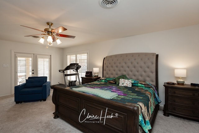 bedroom featuring french doors, visible vents, ceiling fan, and light carpet