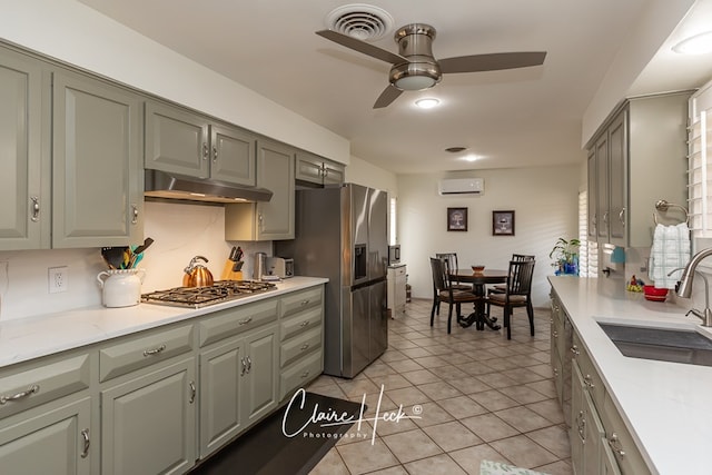 kitchen with visible vents, a wall mounted air conditioner, stainless steel appliances, under cabinet range hood, and a sink