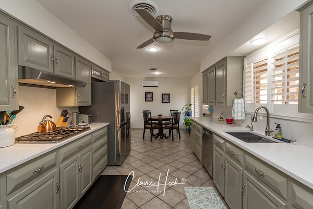 kitchen featuring gray cabinets, appliances with stainless steel finishes, a sink, a wall mounted air conditioner, and under cabinet range hood