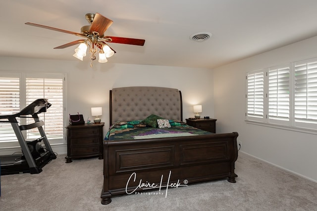 bedroom with multiple windows, visible vents, and light colored carpet