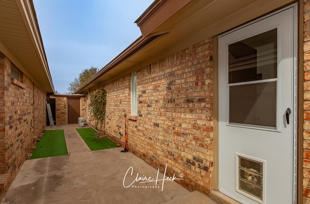 view of side of property with a patio and brick siding