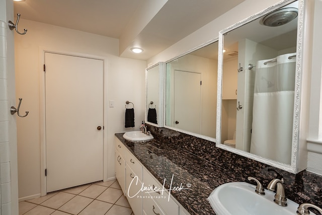 bathroom with tile patterned flooring, a sink, a shower with shower curtain, and double vanity