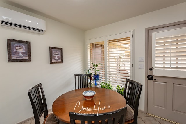 dining space featuring light tile patterned floors, an AC wall unit, and baseboards