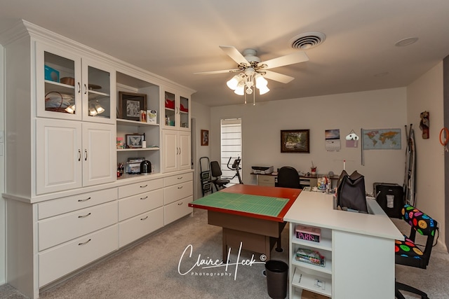 office space featuring light colored carpet, ceiling fan, and visible vents