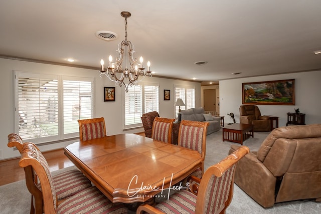 dining area featuring a chandelier, ornamental molding, and visible vents