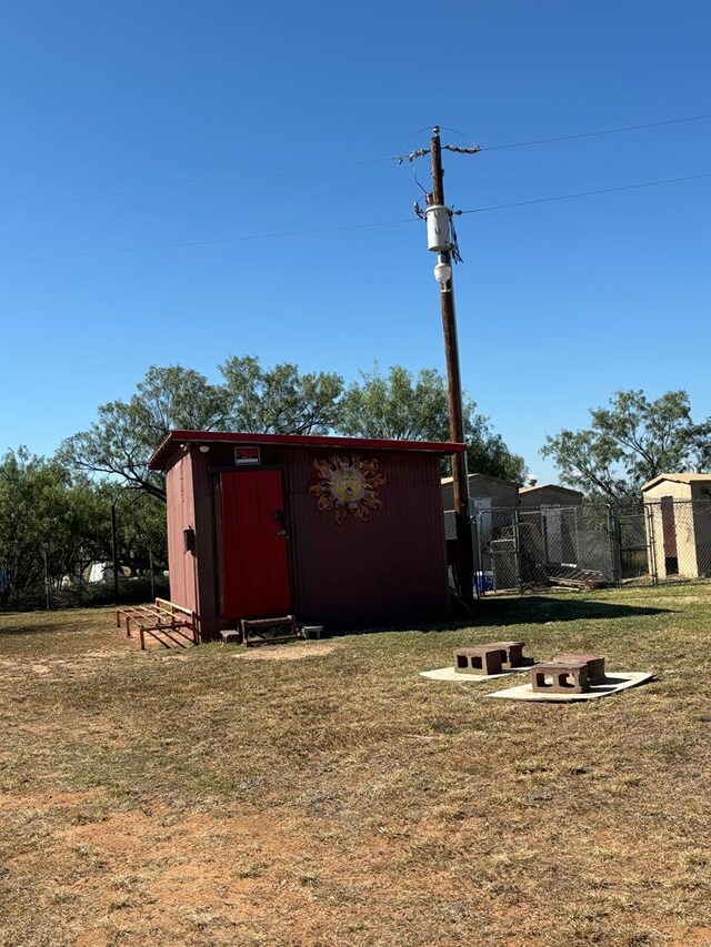 view of outbuilding featuring a yard and an outdoor fire pit