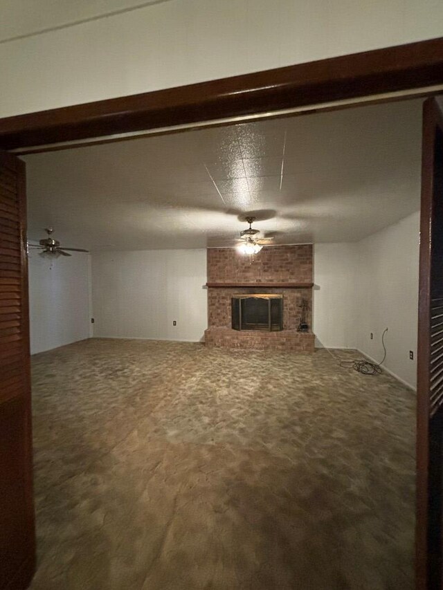 unfurnished living room featuring carpet, ceiling fan, and a fireplace