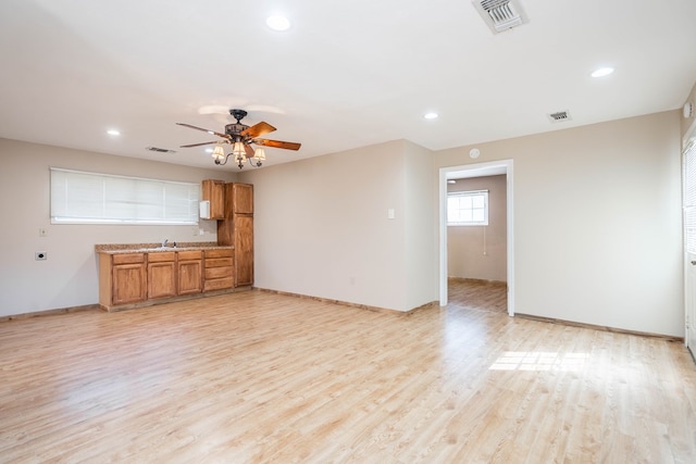 unfurnished living room featuring ceiling fan and light hardwood / wood-style flooring