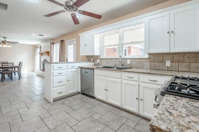 kitchen featuring backsplash, white cabinets, sink, kitchen peninsula, and stainless steel appliances