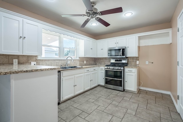 kitchen featuring light stone countertops, white cabinetry, sink, and appliances with stainless steel finishes