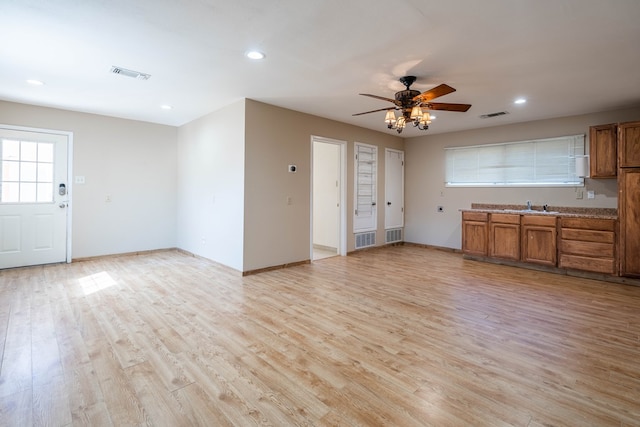 kitchen with ceiling fan, light hardwood / wood-style flooring, and sink