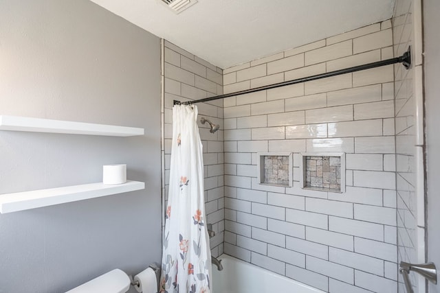 bathroom with a textured ceiling and shower / tub combo with curtain