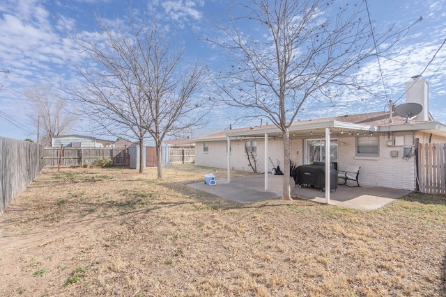 back of house with a lawn, a patio area, and a shed