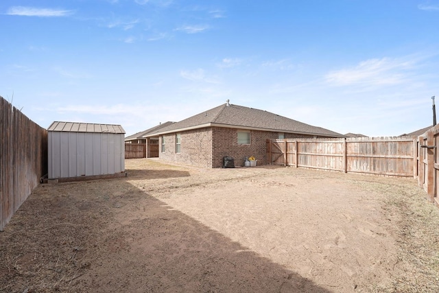 view of yard with an outbuilding, a shed, and a fenced backyard