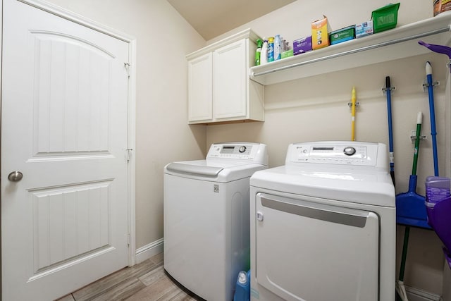 laundry room with light wood-type flooring, cabinet space, baseboards, and independent washer and dryer