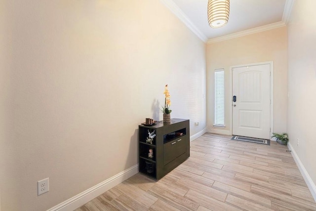 entryway featuring light wood finished floors, baseboards, and crown molding