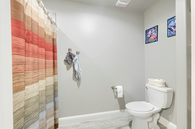 1706 Overshine Ln, Midland, TX 79705 - bathroom with baseboards, toilet, and a shower with curtain