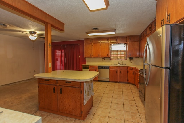 kitchen with appliances with stainless steel finishes, a textured ceiling, ceiling fan, and sink