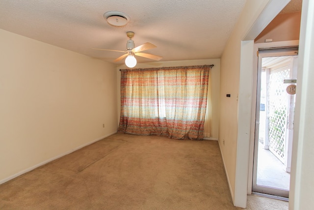 carpeted empty room with a textured ceiling and ceiling fan