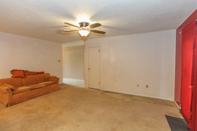 carpeted living room with a textured ceiling and ceiling fan