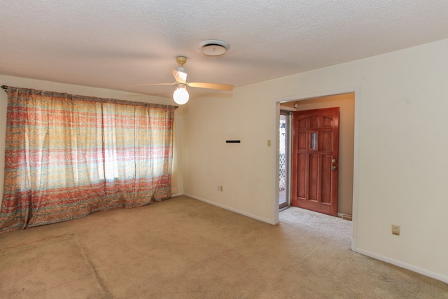 carpeted empty room with ceiling fan and a textured ceiling