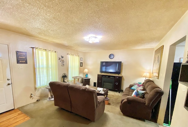 carpeted living room with a fireplace and a textured ceiling