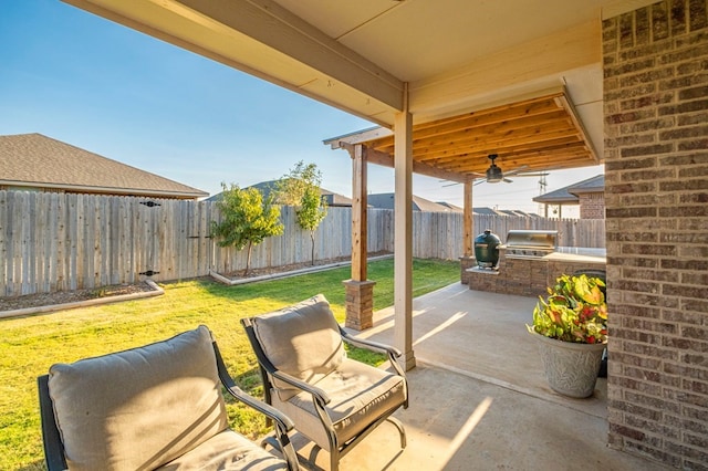 view of patio with an outdoor kitchen, a fenced backyard, and a grill