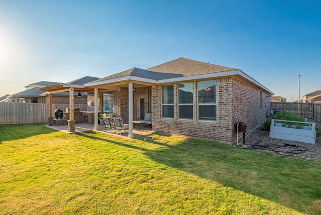 rear view of property featuring a patio, a garden, a yard, a fenced backyard, and brick siding