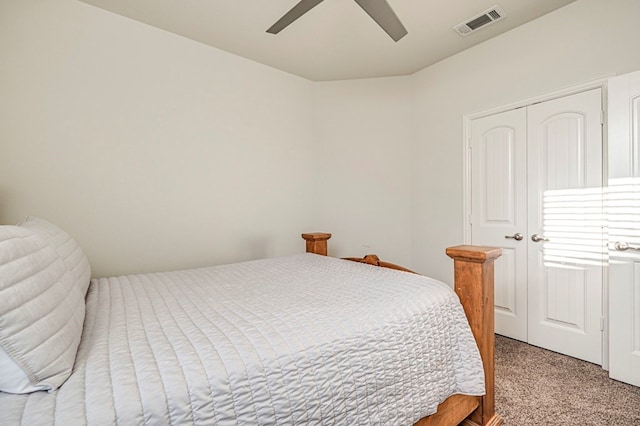 bedroom featuring visible vents, light colored carpet, a closet, and a ceiling fan