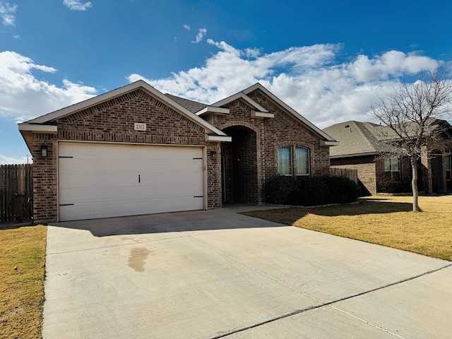 ranch-style house featuring a garage, driveway, brick siding, and a front lawn