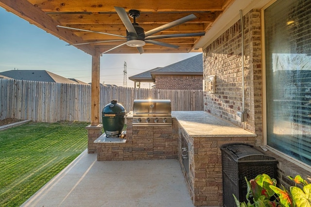 view of patio / terrace with ceiling fan, a grill, exterior kitchen, and a fenced backyard