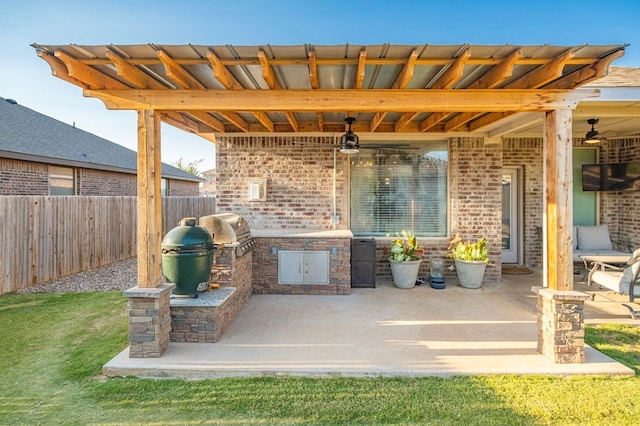 view of patio with a ceiling fan, area for grilling, fence, and a grill