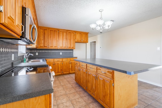 kitchen featuring a kitchen island, tasteful backsplash, a breakfast bar area, hanging light fixtures, and a textured ceiling